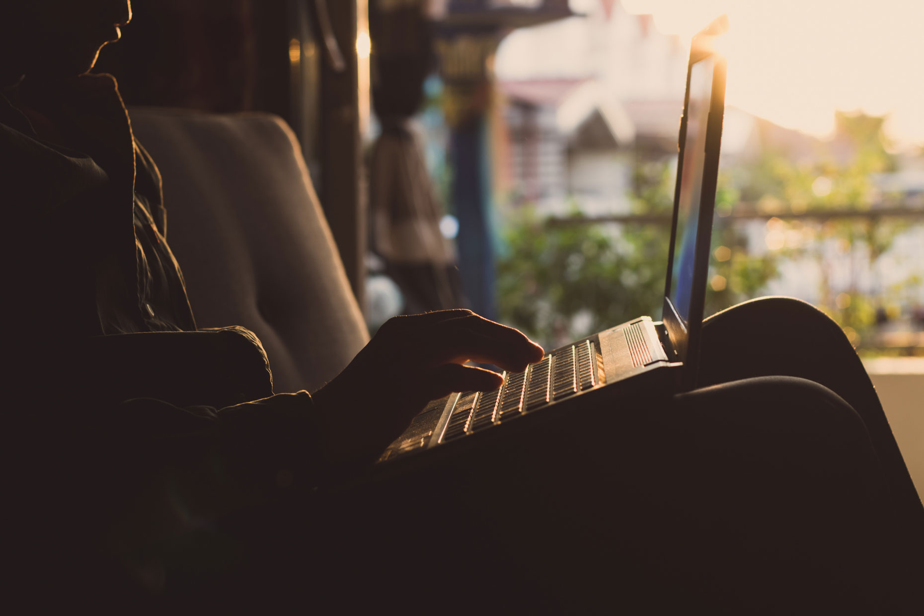 Person working on laptop at sunrise